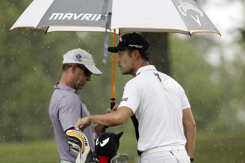 Kevin Na and his caddie try to wait out a rain shower on practice day at the World Golf Championship-FedEx St. Jude Invitational Wednesday, July 29, 2020, in Memphis, Tenn. (AP Photo/Mark Humphrey)