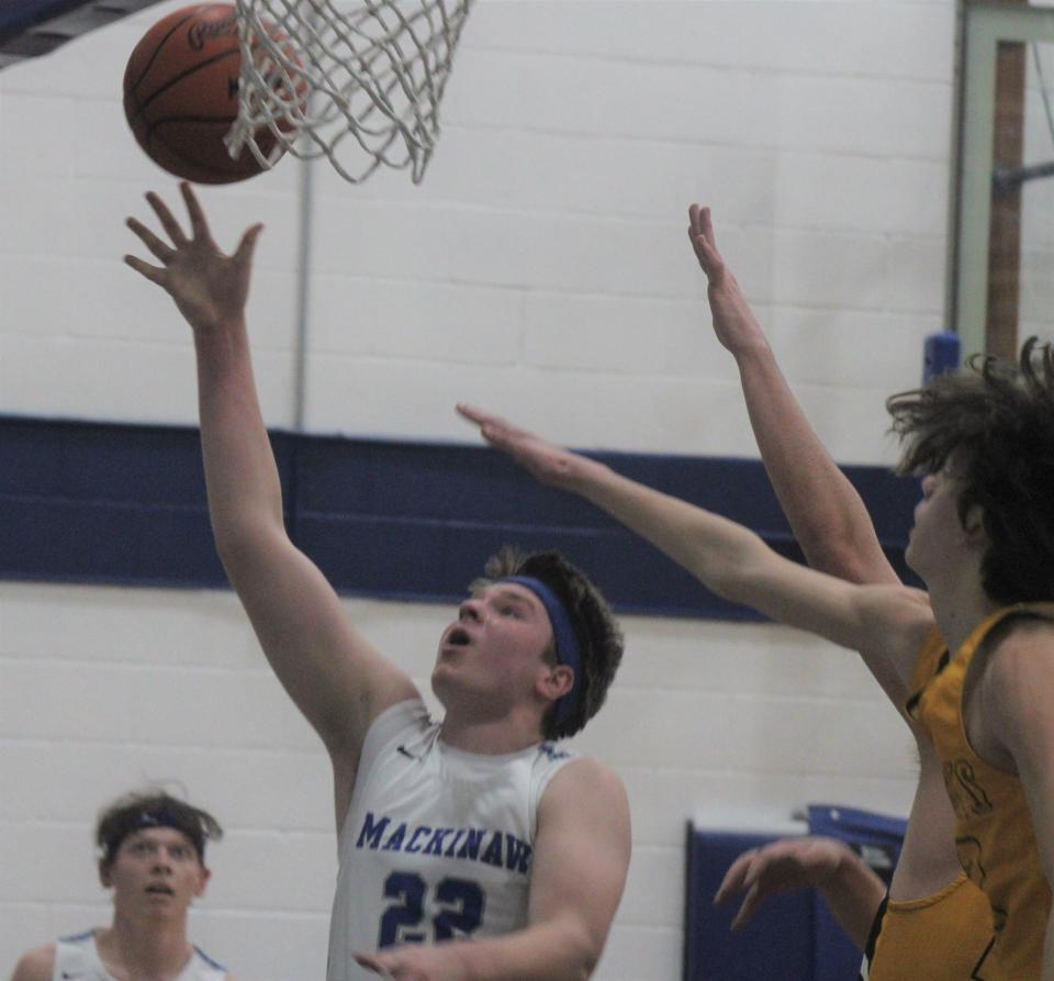 Mackinaw City junior center Lucas Bergstrom (22) scores a basket during the first half of a MHSAA Division 4 boys basketball district semifinal against Pellston in Mackinaw City on Wednesday.