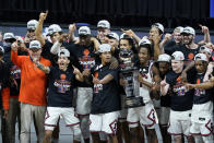 The Illinois team celebrates with the trophy after defeating Ohio State in an NCAA college basketball championship game at the Big Ten Conference tournament, Sunday, March 14, 2021, in Indianapolis. Illinois won in overtime. (AP Photo/Darron Cummings)