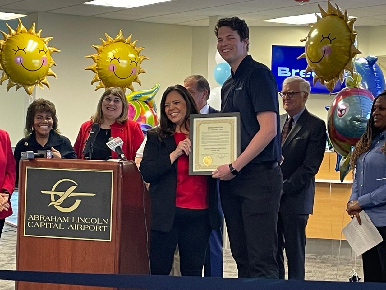 Springfield Mayor Misty Buscher presents Breeze Airways communication specialist Ryne Williams with a City Council proclamation declaring Dec. 1 as "Breeze Airways Inaugural Flight Day" at Abraham Lincoln Capital Airport Friday, Dec. 1, 2023.