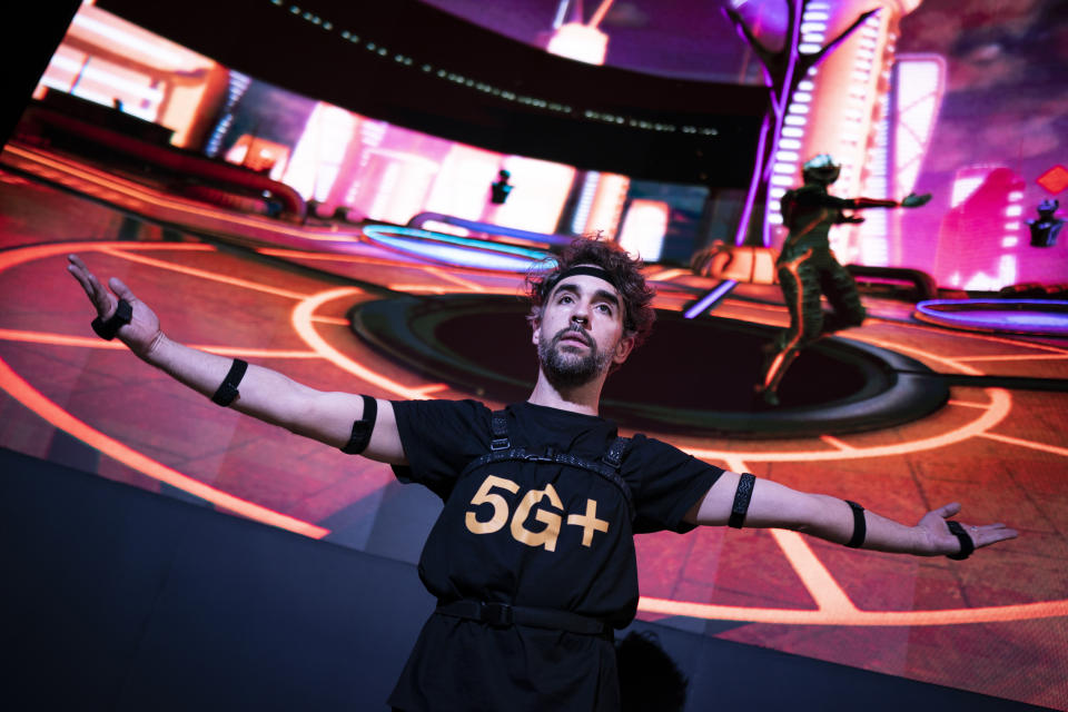 A Orange employee dances during a 5G metaverse dance simulation at the Mobile World Congress 2023 in Barcelona, Spain, Tuesday, Feb. 28, 2023. After three years of pandemic disruption, MWC, also known as Mobile World Congress, kicked off Monday in Barcelona, Spain, with mobile phone makers showing off new devices and telecom industry executives perusing the latest networking gear and software. (AP Photo/Joan Mateu Parra)