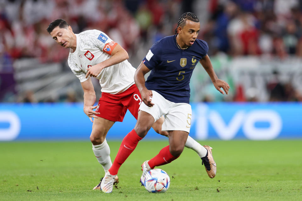 DOHA, QATAR - DECEMBER 04: Jules Kounde of France battles for possession with Robert Lewandowski of Poland during the FIFA World Cup Qatar 2022 Round of 16 match between France and Poland at Al Thumama Stadium on December 04, 2022 in Doha, Qatar. (Photo by Francois Nel/Getty Images)