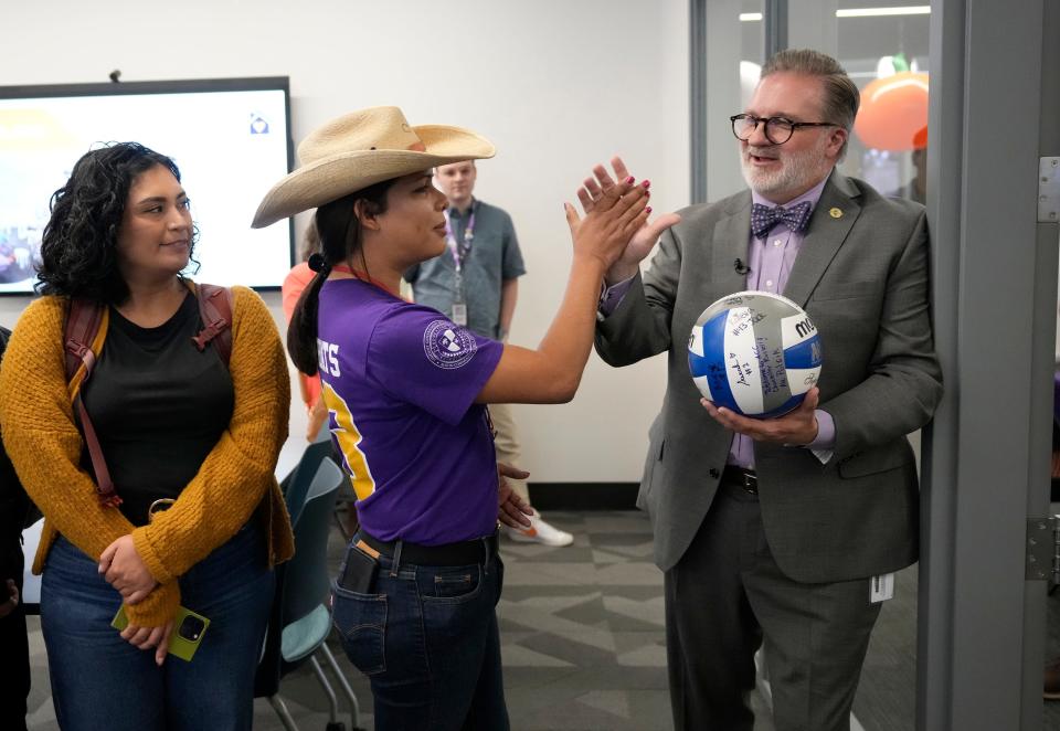 Austin Community College Chancellor Russell Lowery-Hart high-fives student Elisha MacGregor after she gave him an autographed volleyball from the ACC team during a tour of the new welcome center at the Highland campus Monday.