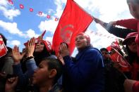 Tunisians wave their national flag and chant slogans during a march against extremism outside Tunis' Bardo Museum on March 29, 2015