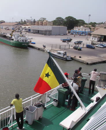 Passengers aboard the Aline Sitoe Diatta ferry look out at the port in Ziguinchor, Senegal, after an overnight trip from Dakar, May 2, 2015. REUTERS/David Lewis