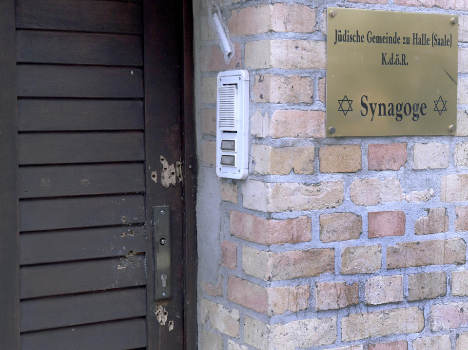 In this Oct.10, 2019 file photo bullet holes in the entrance door of a synagogue are pictured in Halle, Germany. A heavily armed assailant ranting about Jews tried to force his way into a synagogue in Germany on Yom Kippur, Judaism's holiest day, then shot two people to death nearby in an attack Wednesday that was livestreamed on a popular gaming site. (AP Photo/Jens Meyer)