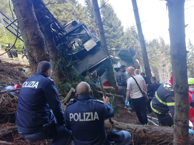 Miembros de la policía y el servicio de rescate trabajan junto a un teleférico destruido luego de que cayó al suelo en Stresa