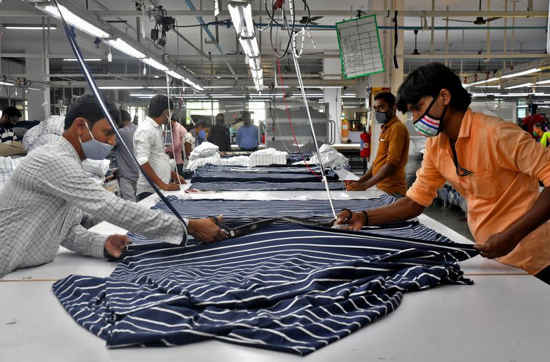 FILE PHOTO: Garment workers cut fabric to make shirts at a textile factory of Texport Industries in Hindupur