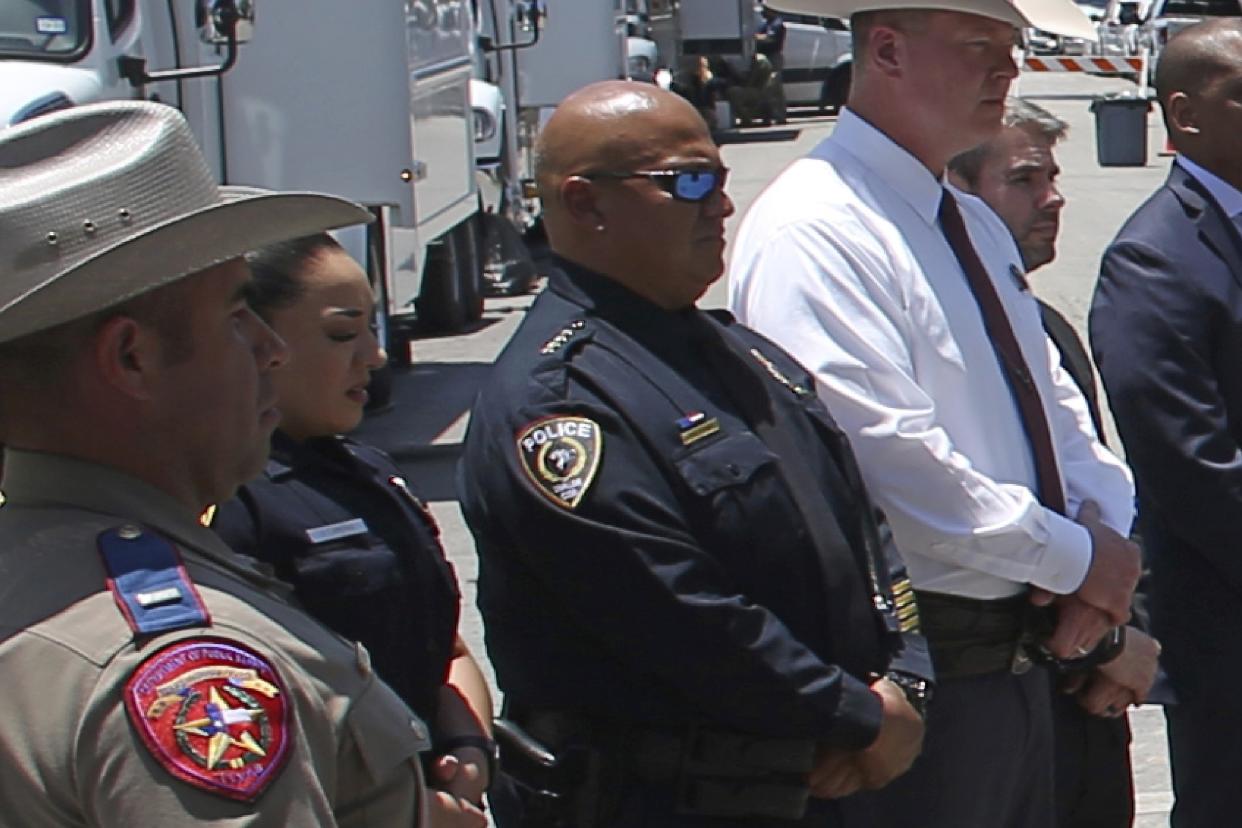 Police Chief Pete Arredondo, in dark glasses, surrounded by other police officers and officials.