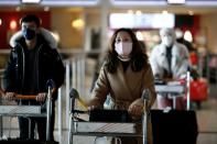 Travellers wearing masks arrive on a direct flight from China, in Paris