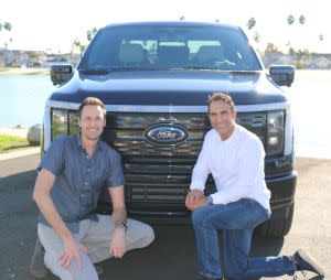 Ford executive Alan Clarke and AMP founder Anil Paryani pose in front of a Ford emblem.