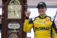 Christopher Bell (20) poses with the trophy in Victory Lane after winning a NASCAR Cup Series auto race at Martinsville Speedway, Sunday, Oct. 30, 2022, in Martinsville, Va. (AP Photo/Chuck Burton)