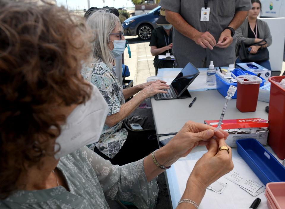 Public health nurse Sheila Winters prepares a bivalent COVID-19 booster shot in this September photo.