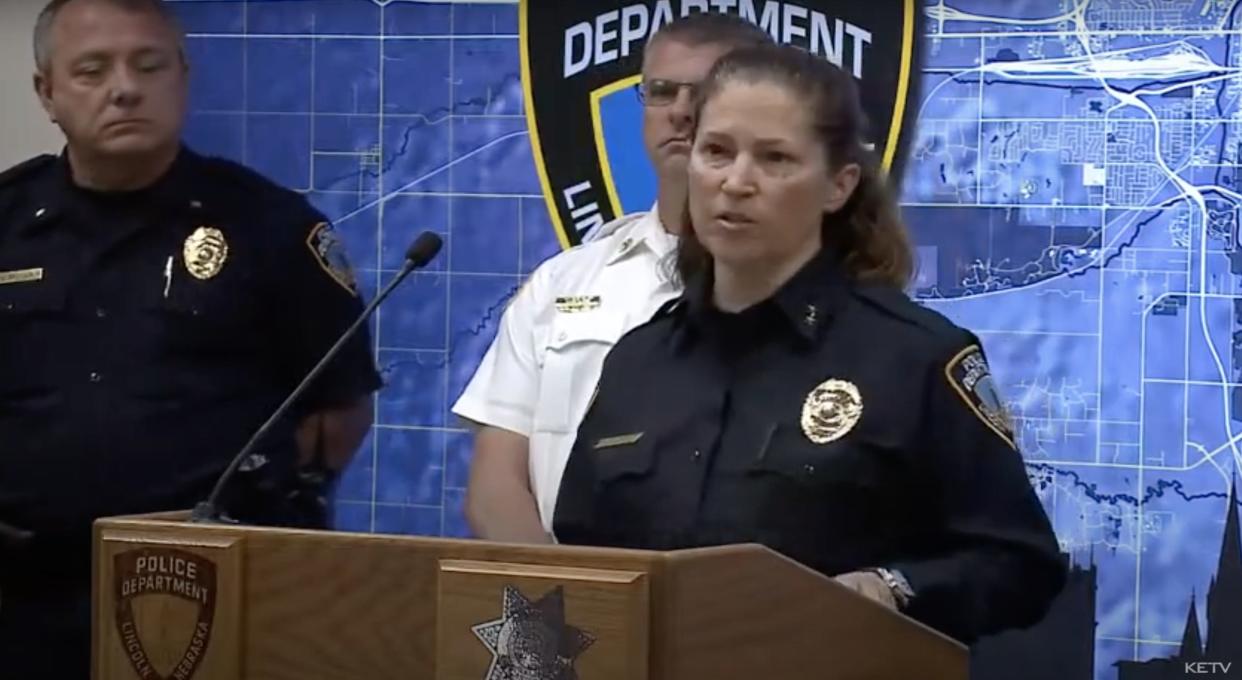 A member of the Lincoln police department against a black, yellow, and blue background.