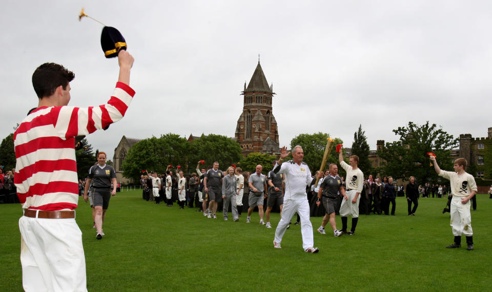 In this handout image provided by LOCOG, Torchbearer 027 John Richards carries the Olympic Flame around the grounds of Rugby School during day 45 of the Olympic Flame Torch Relay on July 2, 2012 in Rugby, England. The Olympic Flame is now on day 45 of a 70-day relay involving 8,000 torchbearers covering 8,000 miles. (Photo by LOCOG via Getty Images)