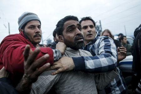 Refugees drag another refugee to the police, accusing him of abusing a young girl, at a makeshift camp at the Greek-Macedonian border near the village of Idomeni, Greece, March 17, 2016. REUTERS/Alkis Konstantinidis