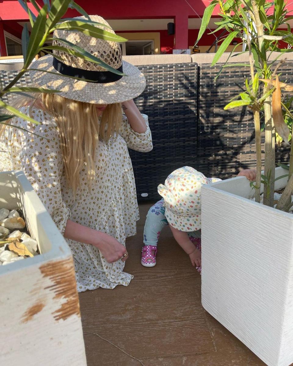 A second image sees Laura Whitmore watch on as daughter Stevie plays on the floor (Laura Whitmore / Instagram)