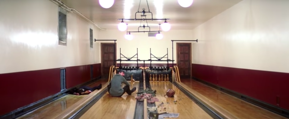 A man sits in a bowling alley