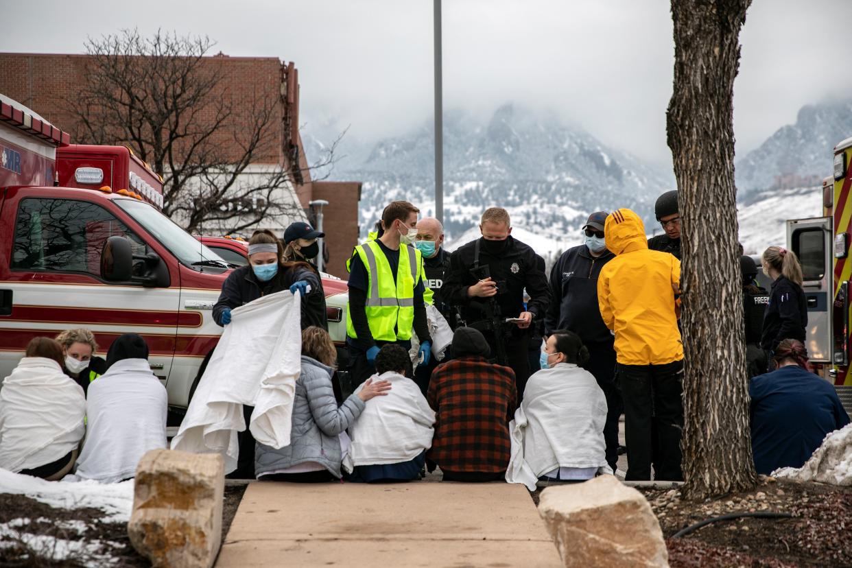 Healthcare workers and shoppers are tended to after being evacuated from a King Soopers grocery store after a gunman opened fire on March 22, 2021 in Boulder, Colorado.