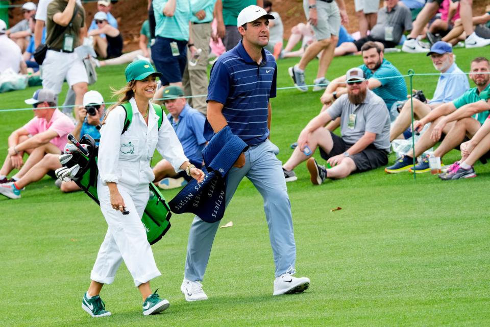 Masters defending champion Scottie Scheffler walks the first fairway with his wife Meredith, during the Par 3 Contest at Augusta National Golf Club.