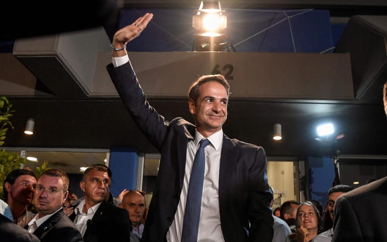 Greece's newly elected Prime Minister Kyriakos Mitsotakis waves at his supporters outside the party's headquarters  - AFP