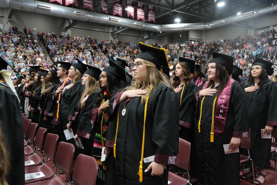 Students stand for the flag Saturday at the WT Commencement Ceremony in Canyon.