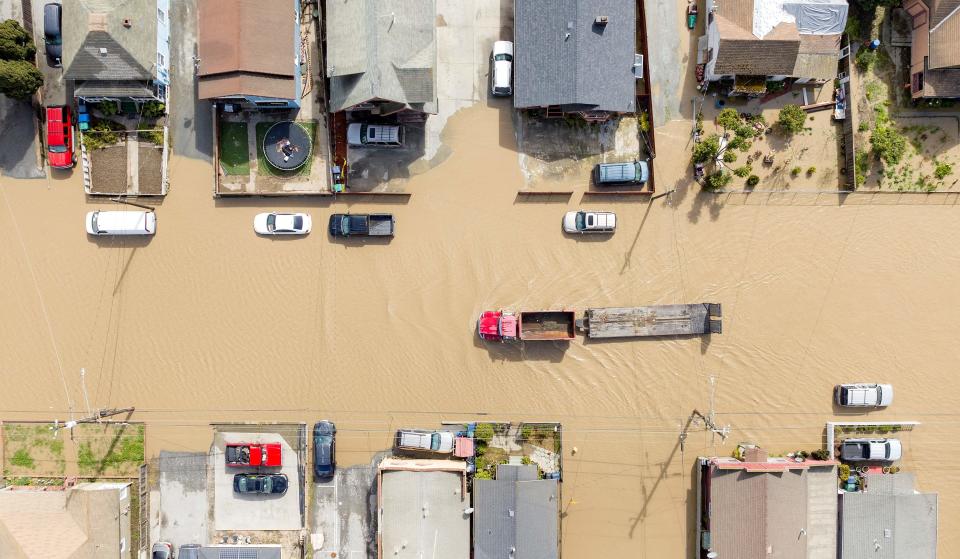 An aerial view shows a truck making its way through a flooded neighborhood in the unincorporated community of Pajaro in Watsonville, California, on March 11, 2023.