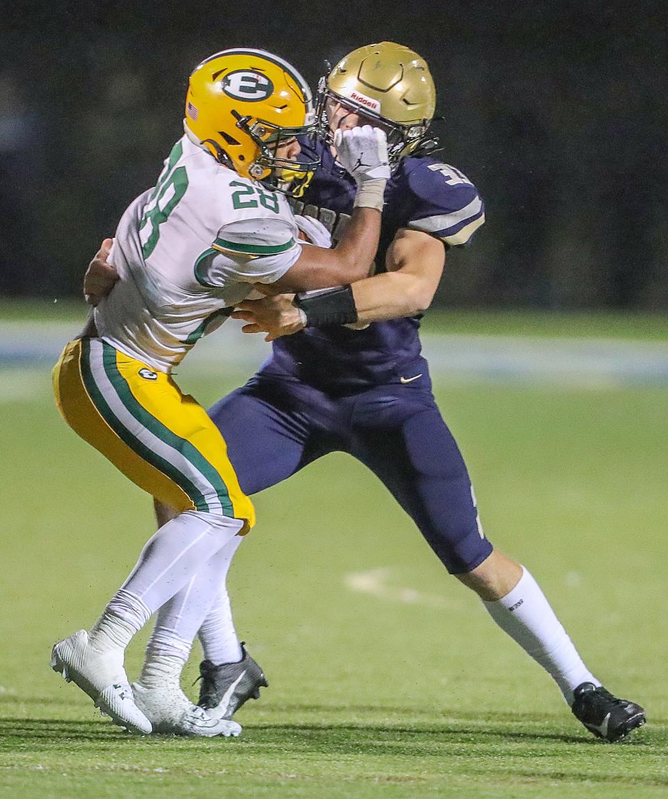 St. Edward running back Brandon White is tackled by Hoban linebacker Eli Lee on Friday in Akron.