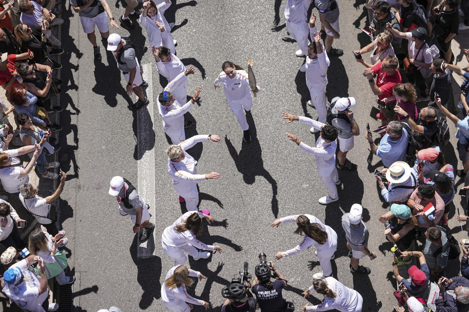 Mariia Vysochanska of Ukraine, accompanied by 27 EU athletes and paraathletes, participates in the Olympic torch relay in Marseille, southern France, Thursday, May 9, 2024. Torchbearers are to carry the Olympic flame through the streets of France' s southern port city of Marseille, one day after it arrived on a majestic three-mast ship for the welcoming ceremony. (AP Photo/Laurent Cipriani)