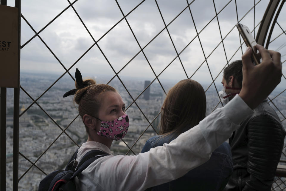 French visitor takes a selfie from the third level during the opening up of the top floor of the Eiffel Tower, Wednesday, July 15, 2020 in Paris. The top floor of Paris' Eiffel Tower reopened today as the 19th century iron monument re-opened its first two floors on June 26 following its longest closure since World War II. (AP Photo/Francois Mori)