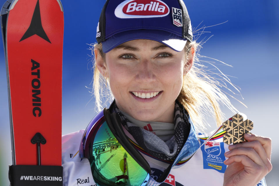 FILE - Mikaela Shiffrin shows her bronze medal on the podium of the women's slalom at the alpine ski World Championships in Cortina d'Ampezzo, Italy, in this Saturday, Feb. 20, 2021, file photo. Shiffrin is certain she wants to participate in every individual women's Alpine ski race at the Beijing Olympics. So as Shiffrin gears up for the start of the World Cup season this month, then looks further down the road toward the trip to Asia in February, she is looking at the various ways in which she can be ready to be at her best in both competitions. (AP Photo/Giovanni Auletta, File)