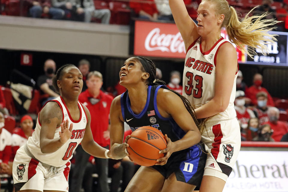 Duke Blue's Elizabeth Balogun, center, tries to shoot while defended by North Carolina State's Diamond Johnson (0) and Elissa Cunane (33) during the first half of an NCAA college basketball game, Sunday, Jan. 16, 2022, in Raleigh, N.C. (AP Photo/Karl B. DeBlaker)