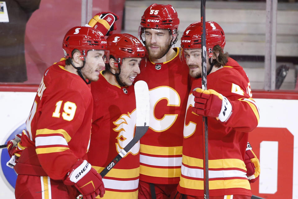 Calgary Flames' Johnny Gaudreau, second from left, celebrates his goal against the Edmonton Oilers with teammates Matthew Tkachuk, Noah Hanifin and Rasmus Andersson, from left, during the second period of an NHL hockey game Saturday, April 10, 2021, in Calgary, Alberta. (Larry MacDougal/The Canadian Press via AP)