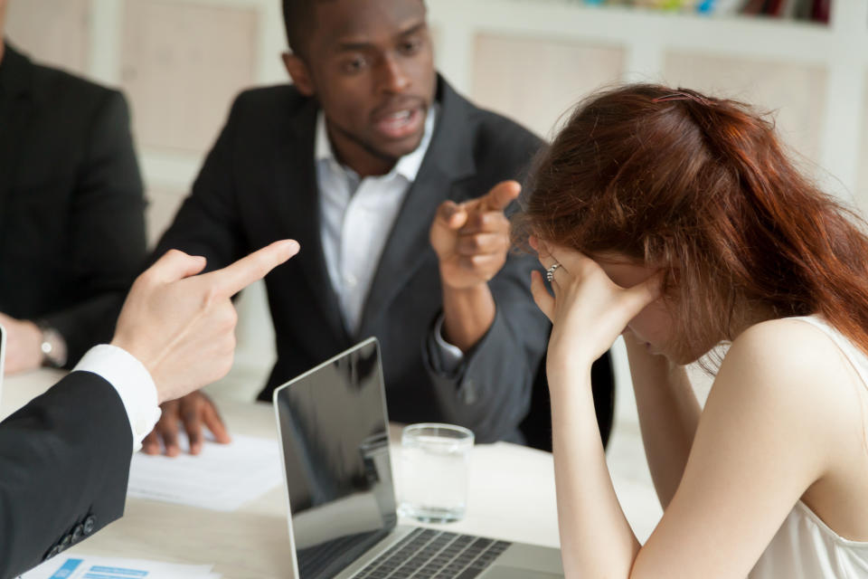 Male colleagues bullying and blaming female associate pointing fingers at her. Woman leader upset and distressed by making mistake leading to failure and problems. Concept of discrimination, stress