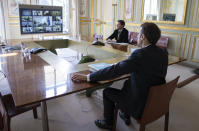 FILE - In this Thursday, March 26, 2020 file photo, French President Emmanuel Macron, right, attends a video conference call with members of the European Council at the Elysee Palace in Paris. European Union leaders are preparing for a new virtual summit, which will take place Thursday, April 23, 2020, to take stock of the damage the coronavirus has inflicted on the lives and livelihoods of the bloc's citizens and to thrash out a more robust plan to revive their ravaged economies. (Ian Langsdon, Pool via AP, File)