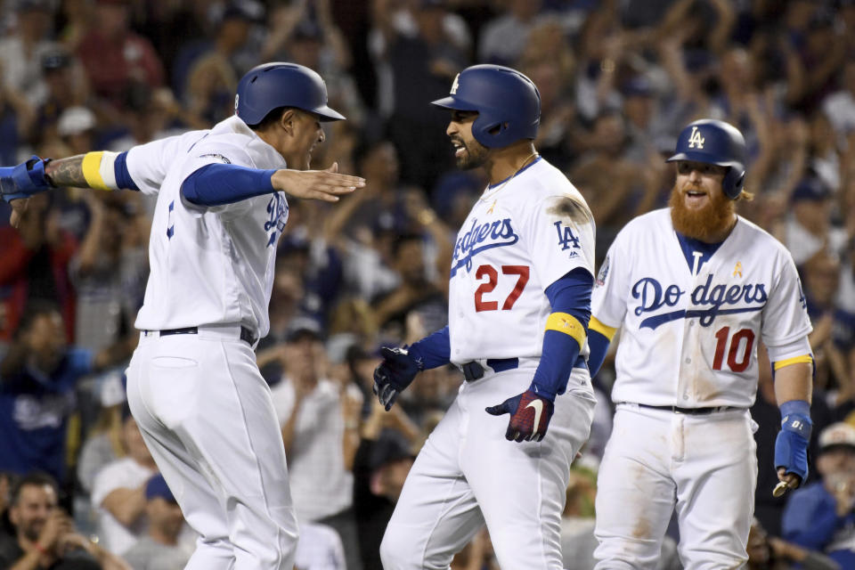 Los Angeles Dodgers' Matt Kemp, center, is greeted at home plate by Manny Machado, left, and Justin Turner after hitting a three-run homer in the eighth inning of a baseball game against the Arizona Diamondbacks, Saturday, Sept. 1, 2018, in Los Angeles. (AP Photo/Michael Owen Baker)