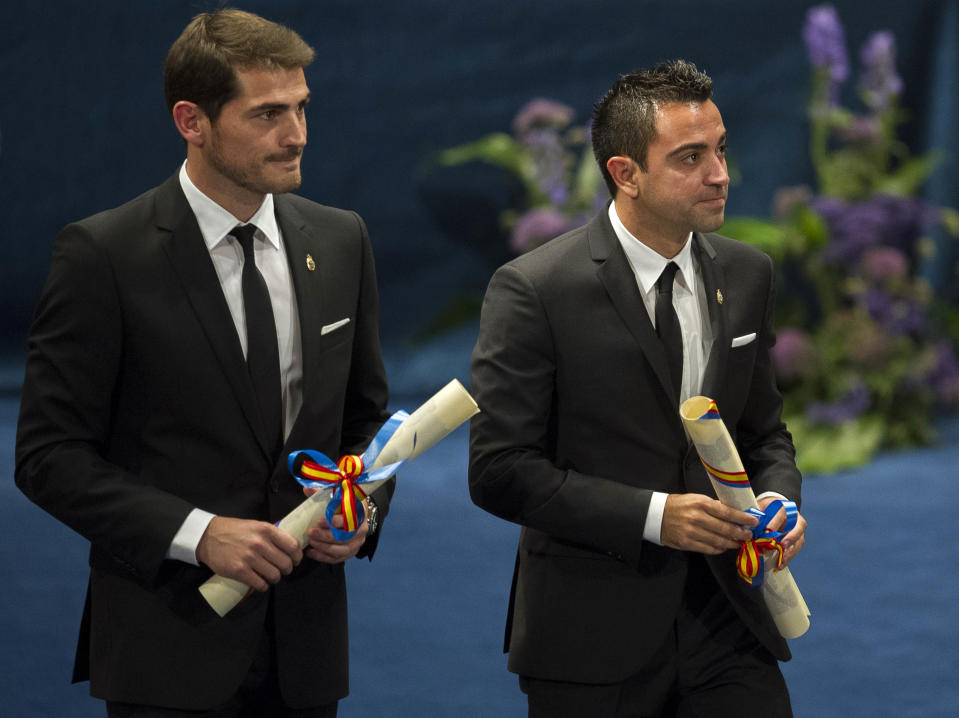 Prince of Asturias prize winners for Sports, Real Madrid soccer player Iker Casillas, left, and FC Barcelona soccer player Xavi Hernandez, right, hold their prizes during an awards ceremony in Oviedo, Spain, Friday Oct. 26, 2012. The award is one of eight of Spain's prestigious Asturias prizes, presented by Spanish Crown Prince Felipe and granted each year in various categories. (AP Photo/Juan Manuel Serrano Arce)