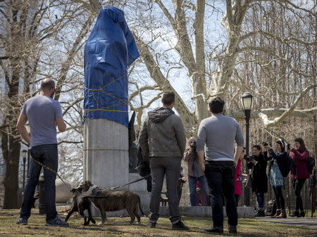 People gather around a covered large molded bust of Edward Snowden at Fort Greene Park in the Brooklyn borough of New York April 6, 2015. REUTERS/Brendan McDermid
