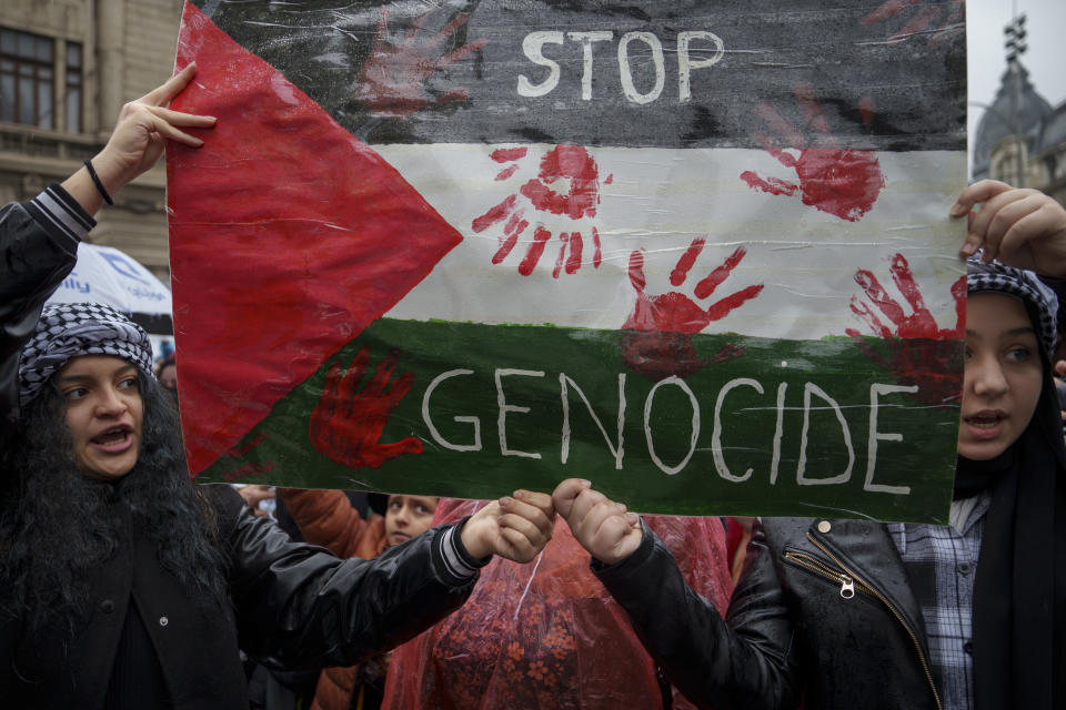 Varias personas gritan consignas durante una protesta en Bucarest, Rumania, el sábado 4 de noviembre de 2023, en apoyo a los palestinos de la Franja de Gaza. (AP Foto/Vadim Ghirda)