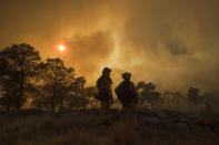 <p>CalFire firefighter Jake Hainey, left, and engineer Anna Mathiasen watch as a wildfire burns near Oroville, Calif., on Saturday, July 8, 2017. The fast-moving wildfire in the Sierra Nevada foothills destroyed structures, including homes, and led to several minor injuries, fire officials said Saturday as blazes threatened homes around California during a heat wave. (AP Photo/Noah Berger) </p>