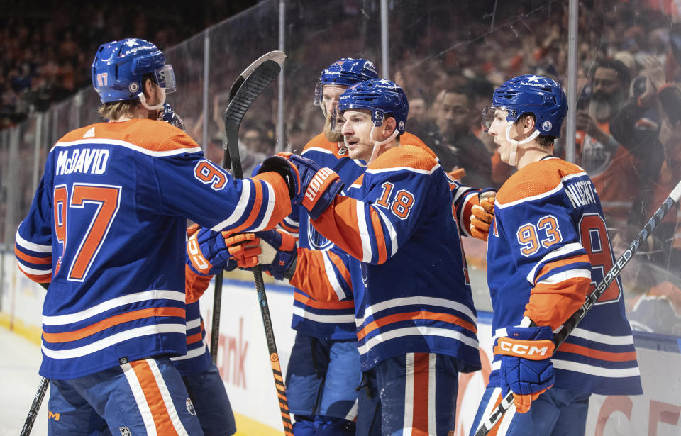 Edmonton Oilers' Connor McDavid (97), Mattias Ekholm, back center, Zach Hyman (18) and Ryan Nugent-Hopkins (93) celebrate a goal against the Florida Panthers during the second period of an NHL hockey match in Edmonton, Alberta, on Saturday Dec. 16, 2023. (Jason Franson/The Canadian Press via AP)