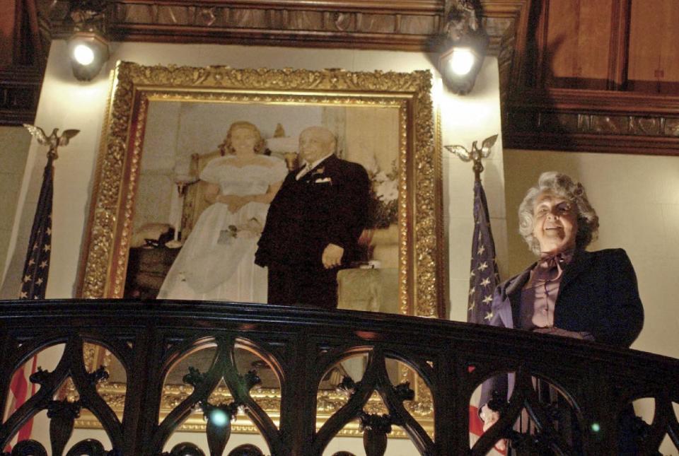 FILE – In this May 21, 2003, file photo, Mother Divine looks down from a stairwell while standing near a portrait of herself and her late husband Father Divine at her home at Woodmont in Gladwyne, Pa. Mother Divine, the leader for decades of the religious movement Father Divine founded that advocated racial equality and provided free food to thousands of people, died Saturday, March 4, 2017, at the movement's Gladwyne estate, according to the Emil J. Ciavarelli Family Funeral Homes. She was believed to be 92. (AP Photo/Jacqueline Larma, File)