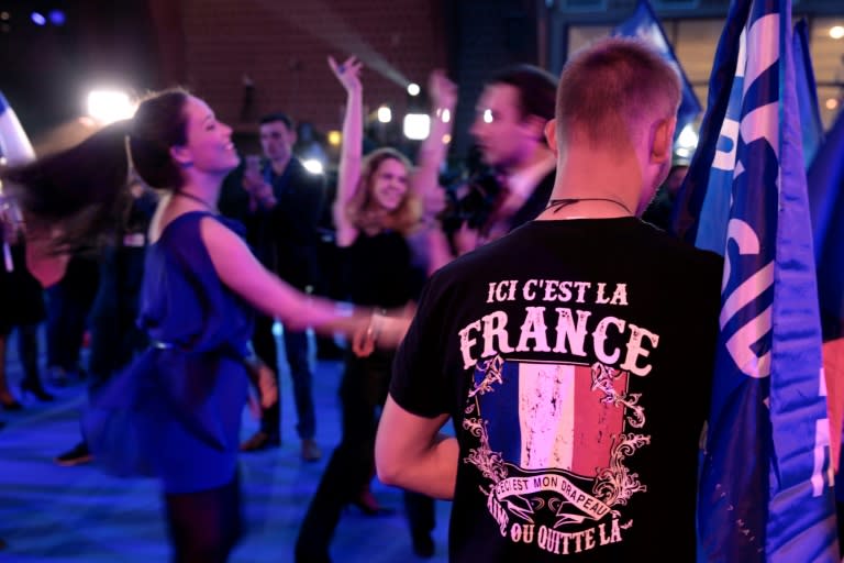 National Front supporters dance after projections that party leader Marine Le Pen will contest the runoff in France's presidential election on May 7