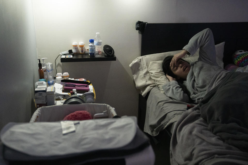 Tiffany Patino, who has struggled with Long COVID symptoms for a year, rests in bed with most of the lights off at her home in Rockville, MD on December 2, 2021. (Photo by Carolyn Van Houten/The Washington Post via Getty Images)