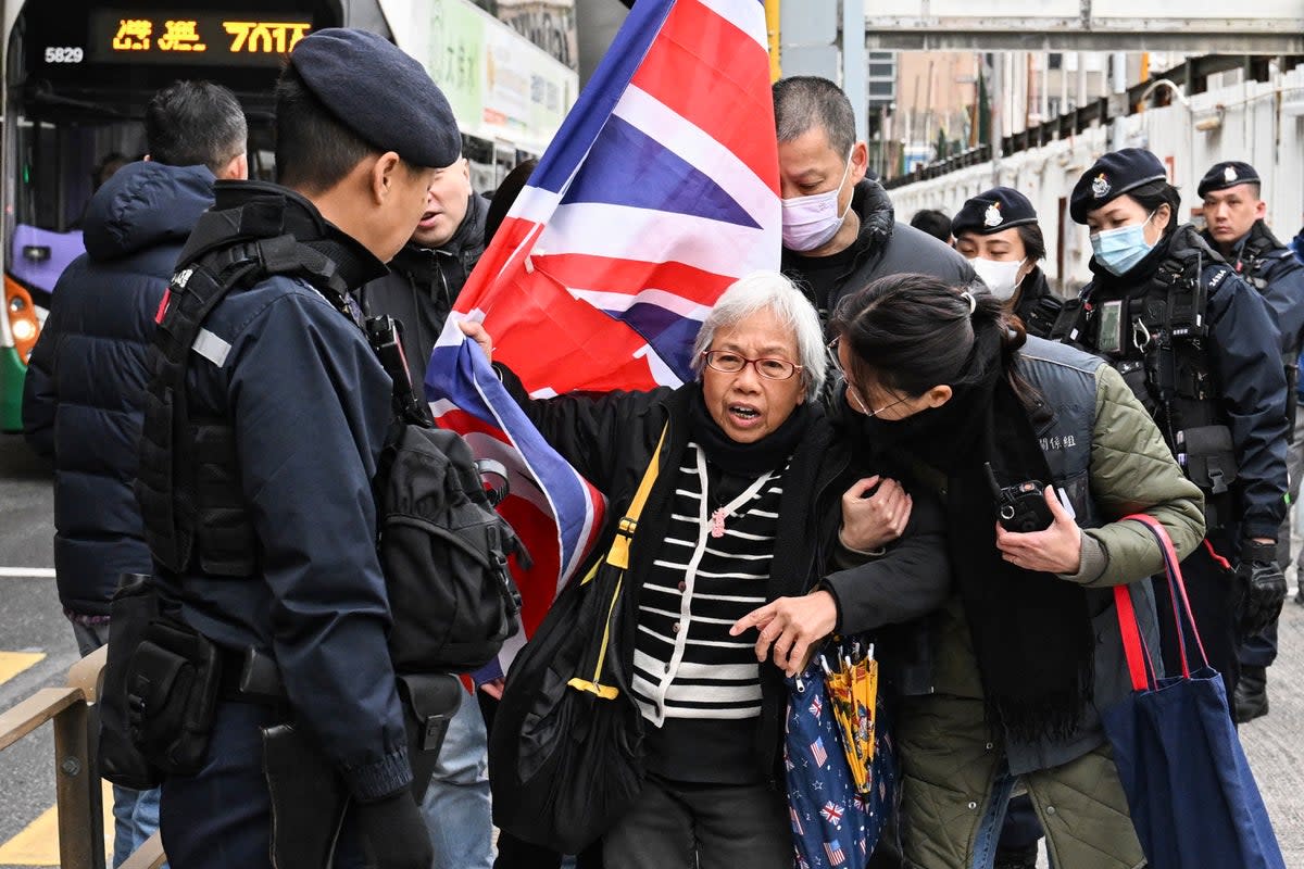 Policemen stop activist Alexandra Wong, also known as Grandma Wong, as she carries a union flag outside the West Kowloon court ahead of the trial of pro-democracy media tycoon Jimmy Lai on Friday (AFP/Getty)