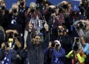 Rafael Nadal of Spain raises his trophy after defeating Novak Djokovic of Serbia in their men's final match at the U.S. Open tennis championships in New York, September 9, 2013.