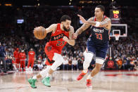 Toronto Raptors guard Fred VanVleet (23) drives against Washington Wizards forward Kyle Kuzma (33) during first-half NBA basketball game action in Toronto, Sunday, Dec. 5, 2021. (Cole Burston/The Canadian Press via AP)