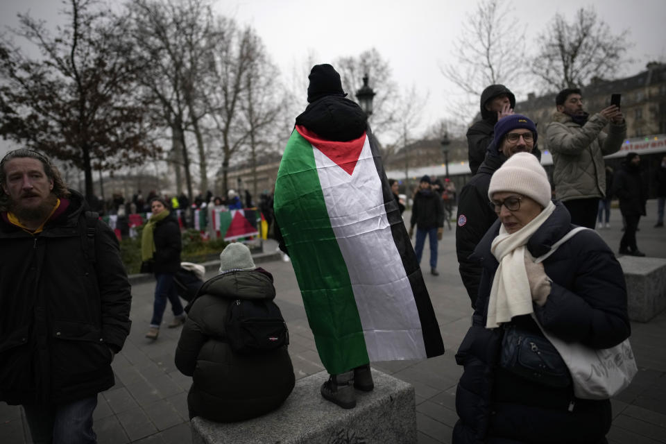 A demonstrator with a Palestinian flag attends a pro-Palestinian rally in Paris, Saturday, Jan. 13, 2024. (AP Photo/Christophe Ena)