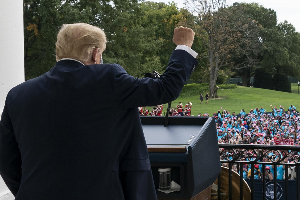 President Donald Trump pumps his fist to the crowd with a bandages on his hand, before speaking from the Blue Room Balcony of the White House to a crowd of supporters, Saturday, Oct. 10, 2020, in Washington. (AP Photo/Alex Brandon)