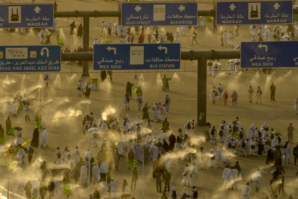 A water is sprayed on pilgrims to cool them as they walk to cast stones at a pillar in the symbolic stoning of the devil, the last rite of the annual Hajj pilgrimage, in Mina near the holly city of Mecca, Saudi Arabia, Wednesday, June 28, 2023. (AP Photo/Amr Nabil)